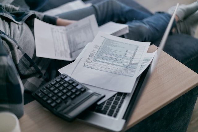 papers on laptop with calculator