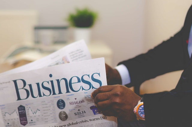 man in suit reading a business newspaper