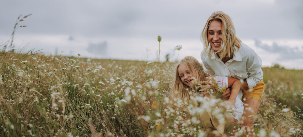 Happy woman having fun with her daughter in a field